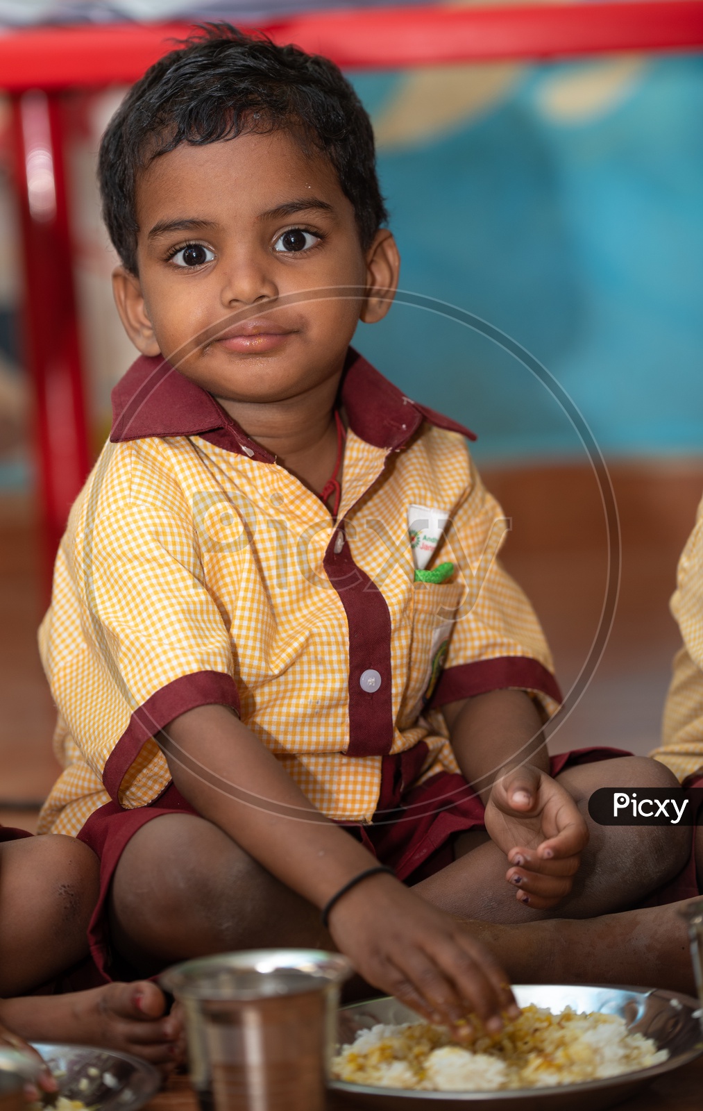 Portrait of a young boy eating his mid day meal in an Anganwadi centre