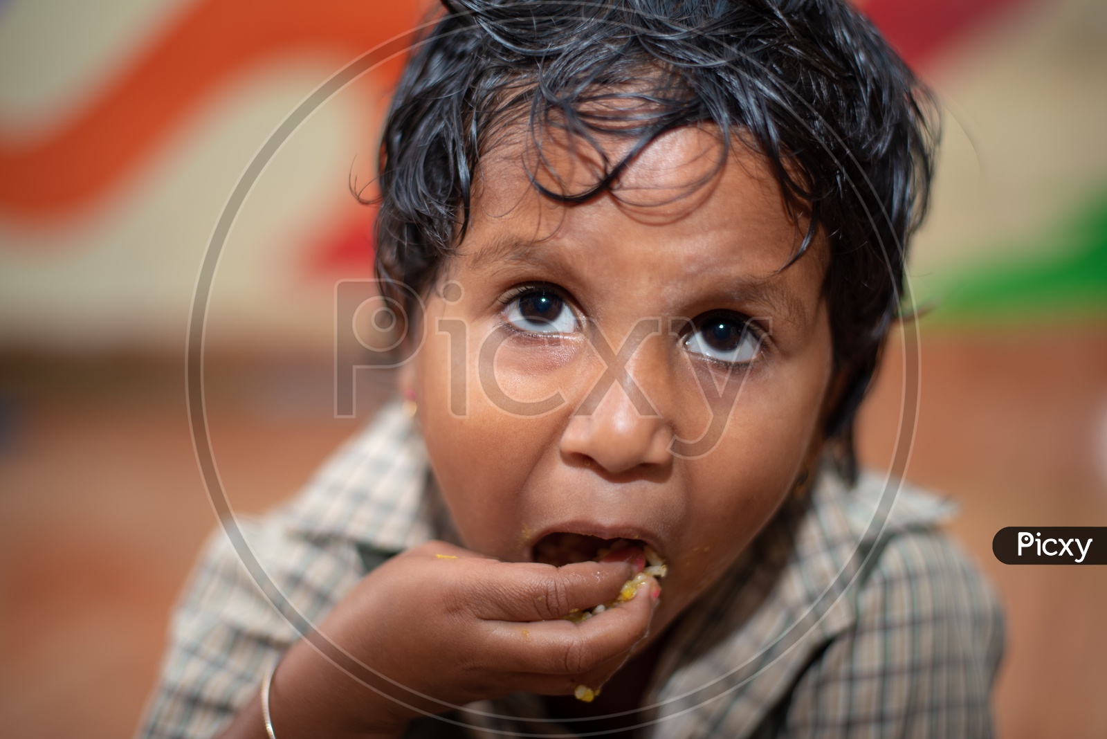 Portrait of a young boy eating his mid day meal in an Anganwadi center