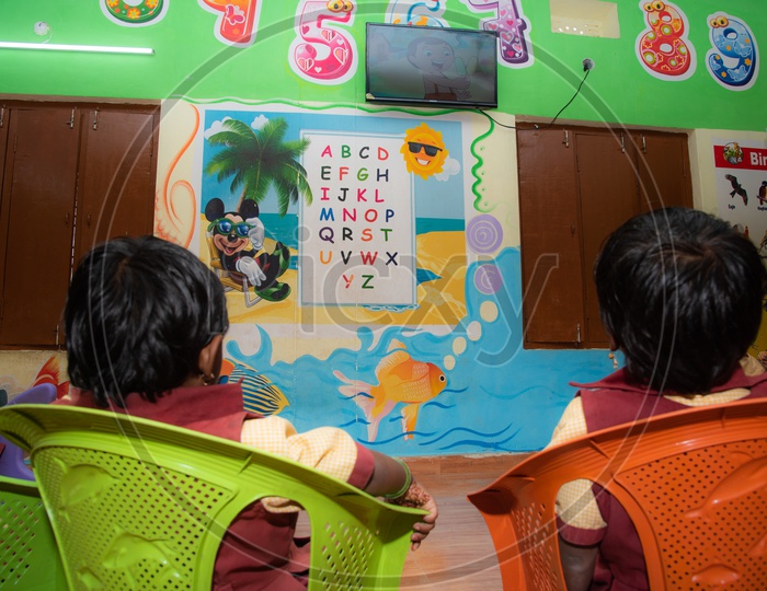 Students watching educational rhymes on a Led TV in Anganwadi center