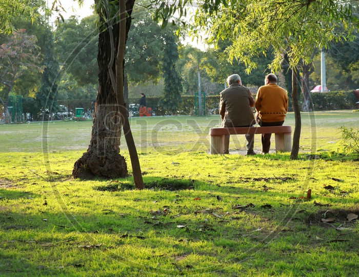 Two Old men sitting on a bench in town park