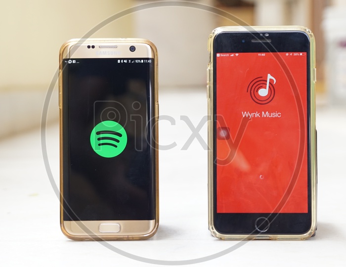 Smartphones with Spotify app and Wynk app on screen