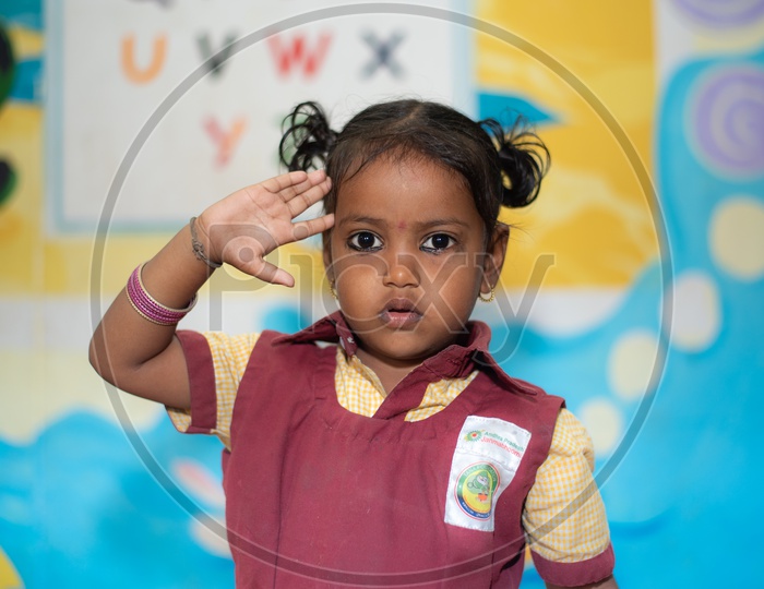 Portrait of a girl child saluting in an Anganwadi center