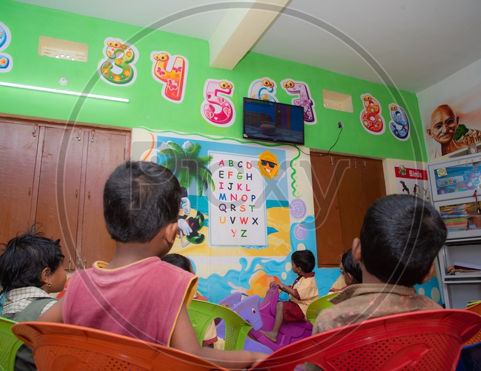 Students watching educational rhymes on a Led TV in Anganwadi center