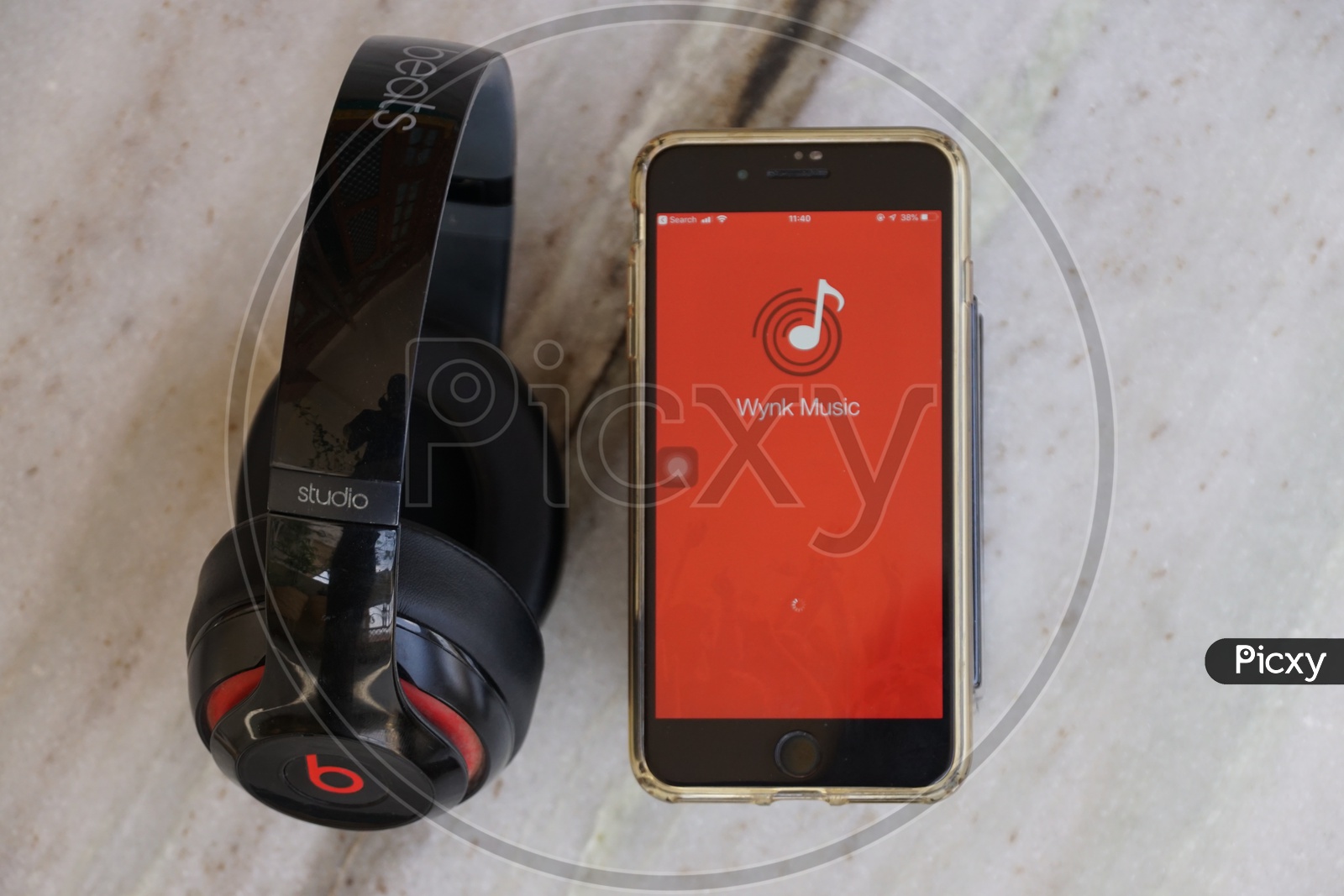 Flat lay of headphone and smart phone with Wynk app icon on screen