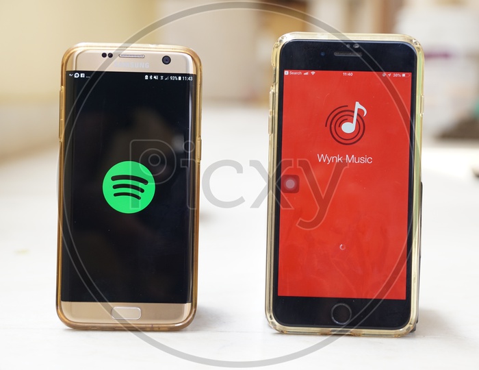 Smartphones with Wynk Music and Spotify Applications on Screen