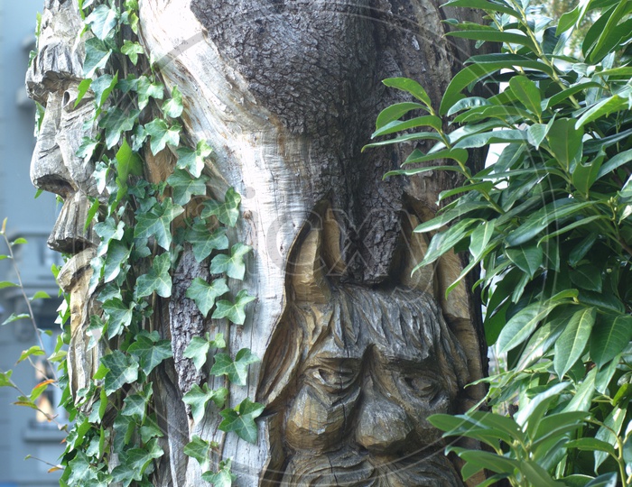 A stone carving covered with garden plants