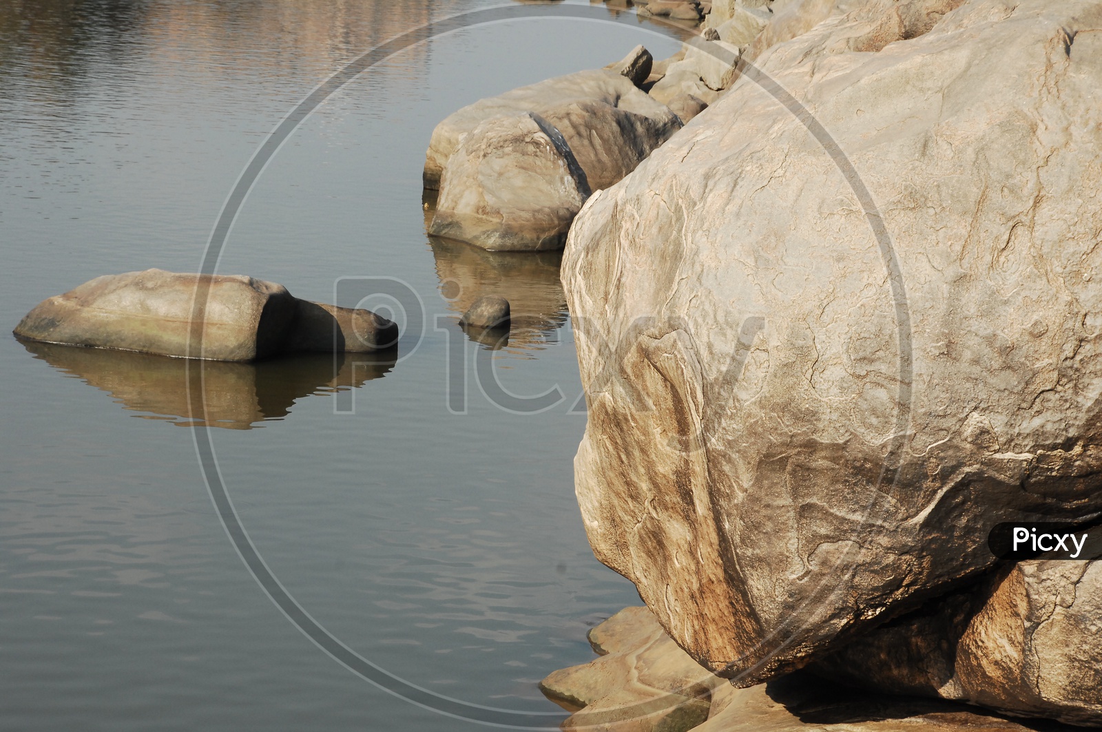 Large rocks inside and beside a lake