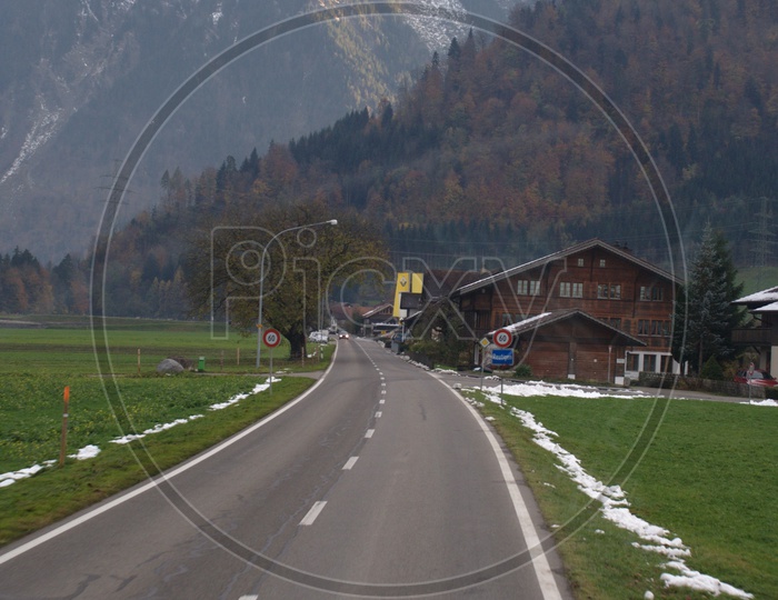 Roadway through the Green meadow alongside the Swiss Alps