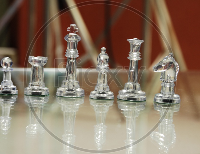 Transparent Staunton chess pieces on glass
