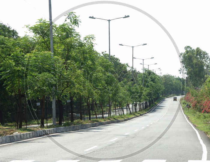 An empty tar road in a urban area with greenery