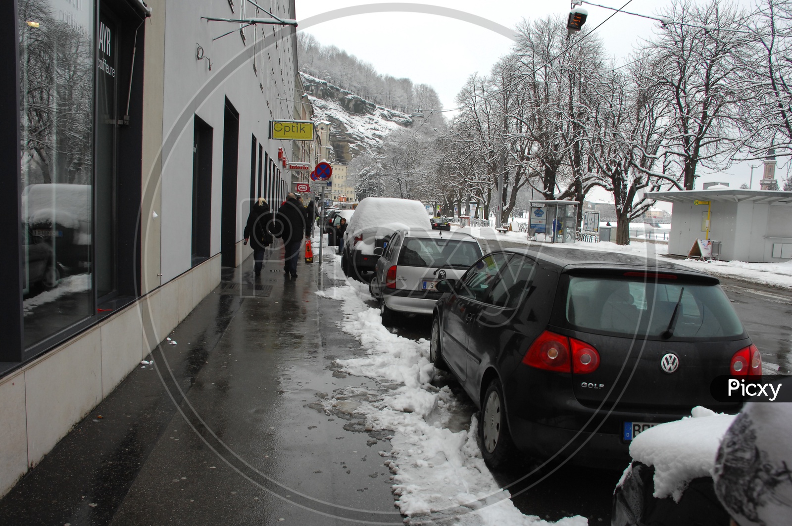 Cars parked alongside the road covered with snow