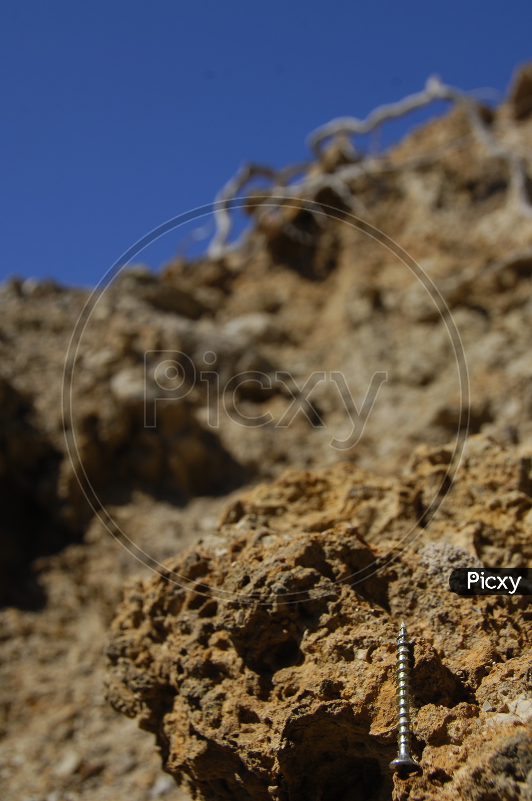close shot of a rock and a screw on it