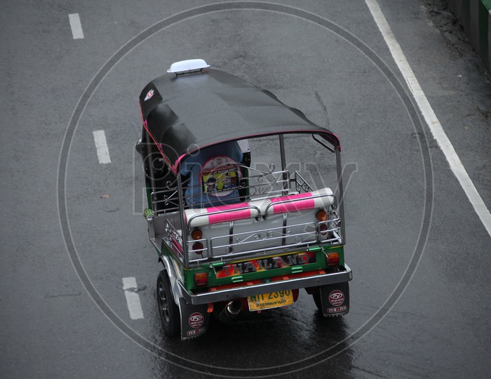 A rickshaw moving on a wet road