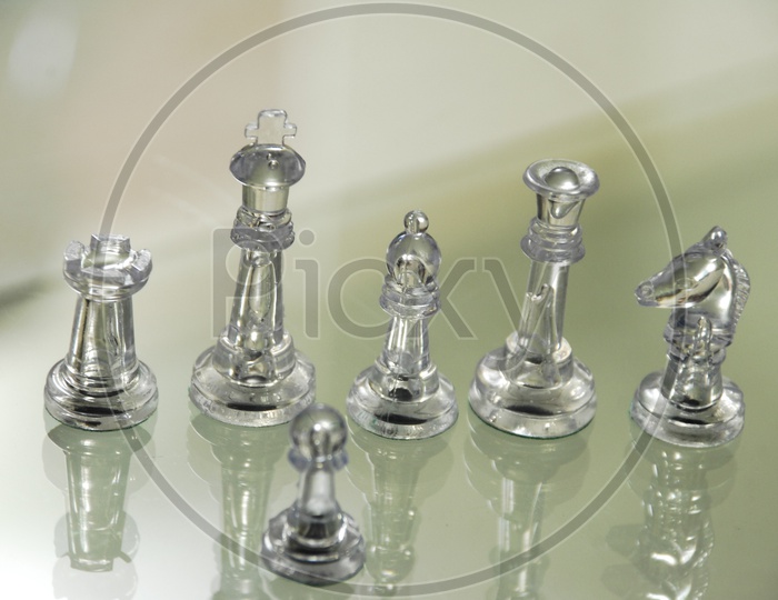 Transparent chess pieces on a glass