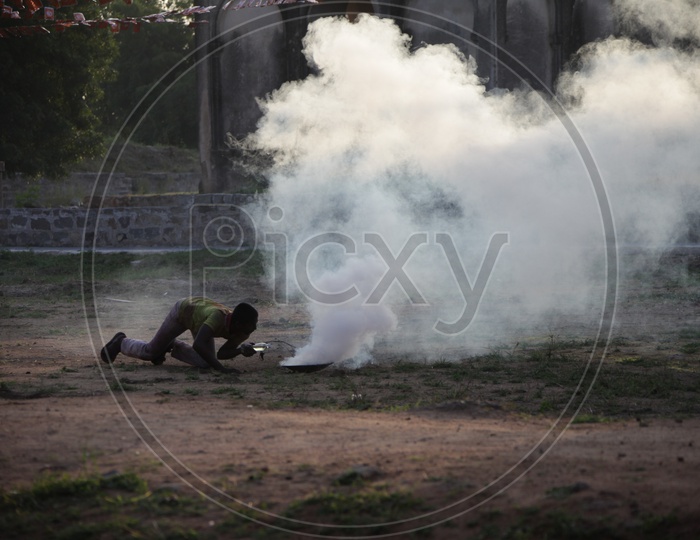A Person Making Thick Smoke for Movie Shooting