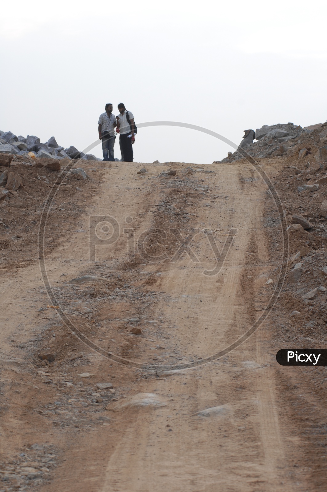 Two men standing alongside a quarry road