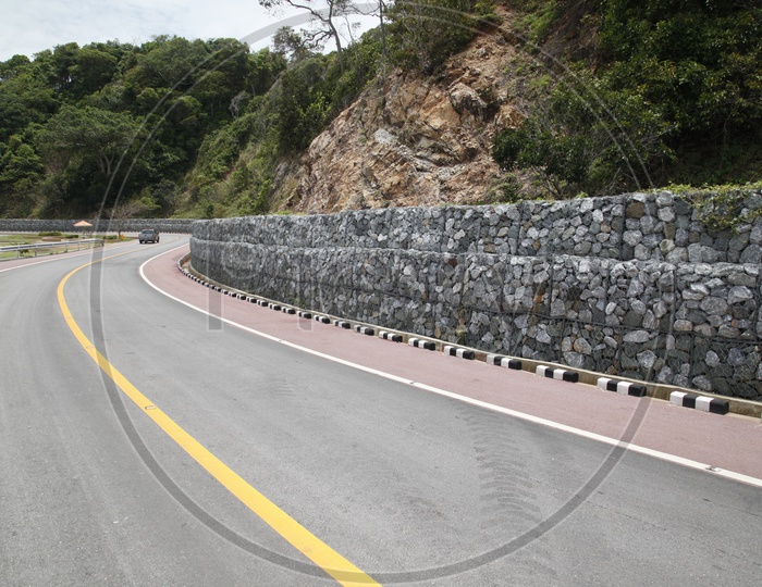 View of rock wall alongside the road curve