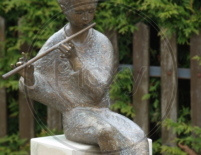 A Boy Playing Flute  Statue