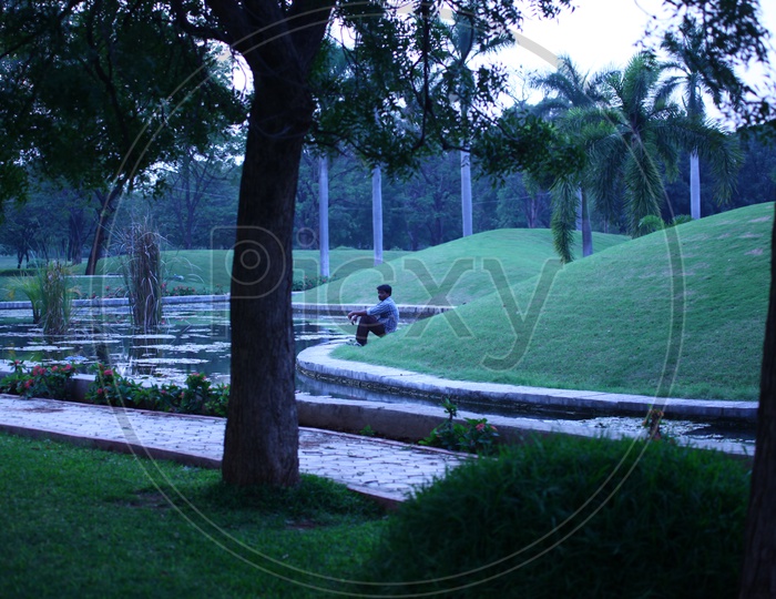 Man sitting alongside the green lawn