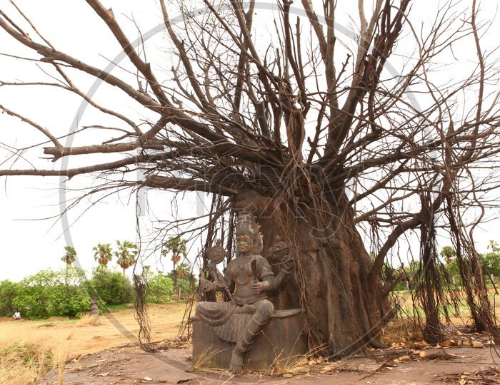 Hindu Goddess sculpture alongside the tree