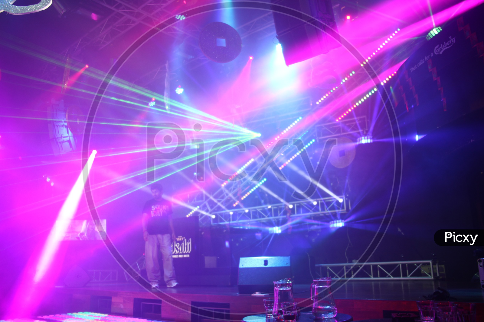 Man standing on the stage with Laser lights in the night club