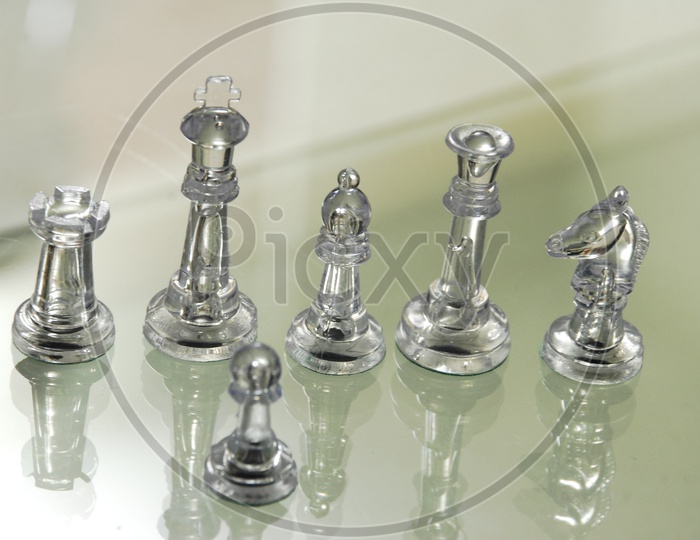 Transparent chess pieces on glass