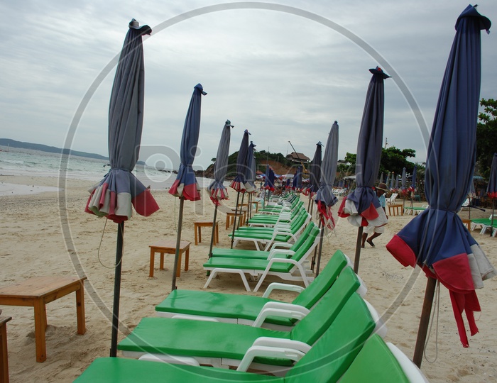 Beach beds with closed umbrellas