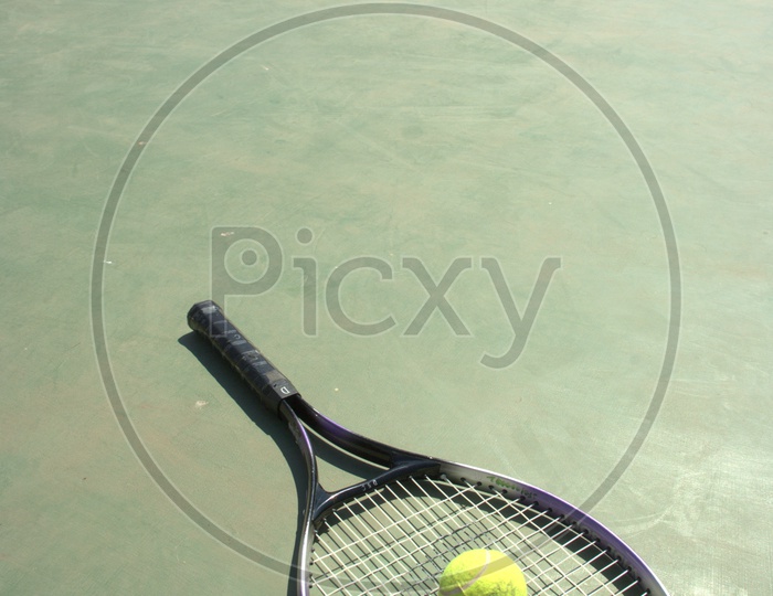 Tennis racket and a ball in the court