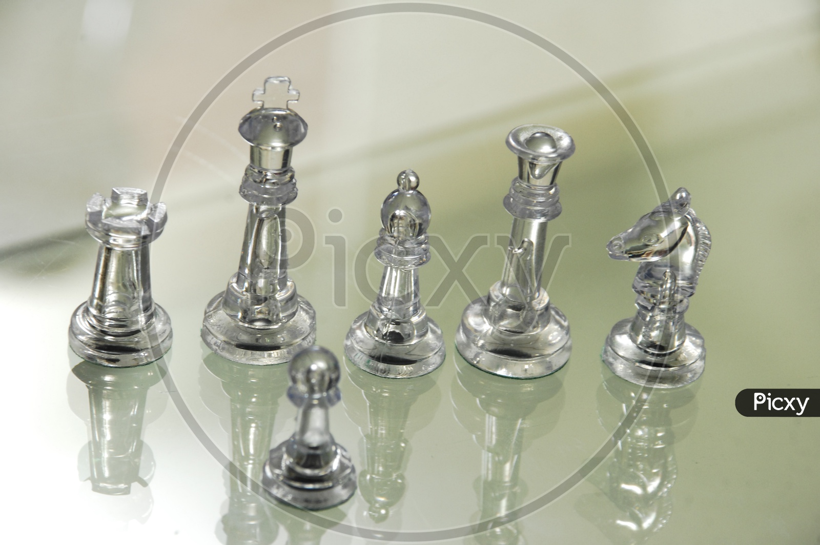 Transparent chess pieces on glass