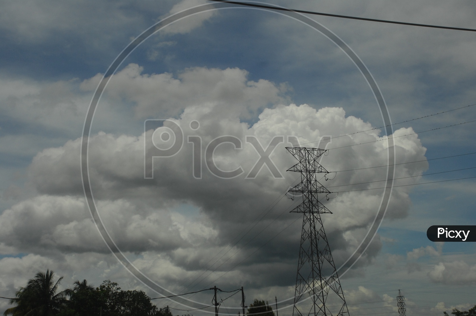 View of cumulus clouds alongside the hi tension power lines