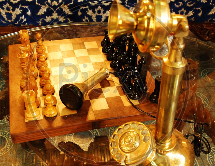Antique vintage telephone and chess board on table