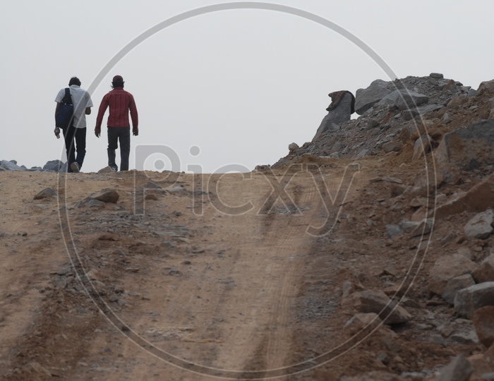 Two men walking along the muddy road