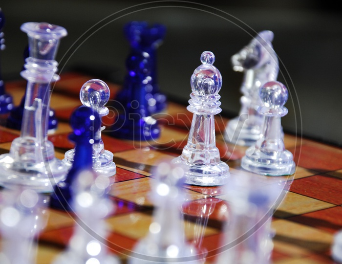 Blue and transparent chess pieces on chess board
