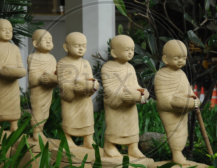 Statues of kids standing with bowls