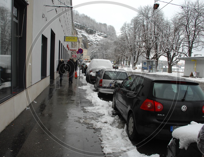 Cars parked alongside the road covered with snow