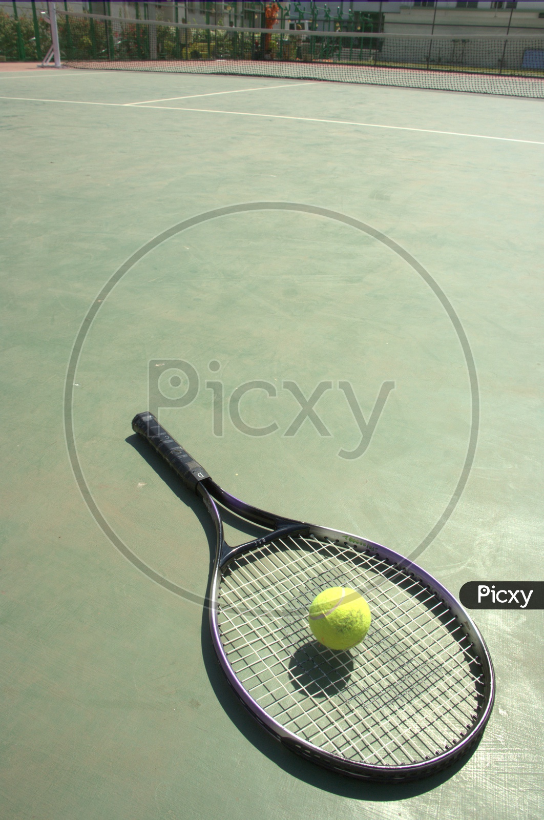 Tennis racket and a ball in the court