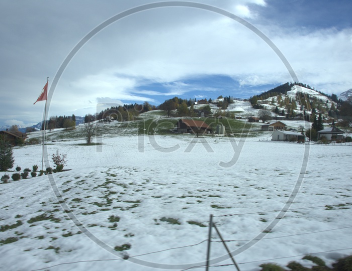 Snow on the grass alongside the Swiss alps