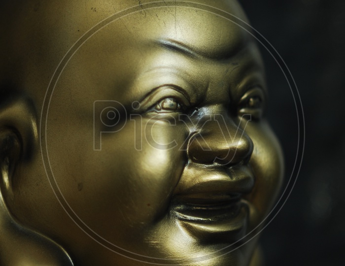 A bronze sculpture of laughing Buddha