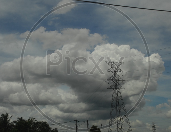 View of cumulus clouds alongside the hi tension power lines