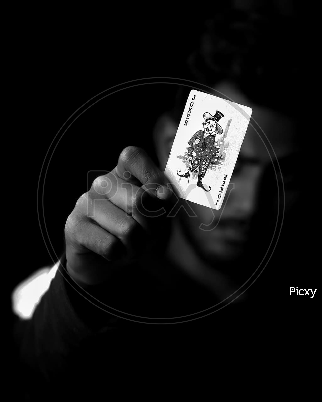 A person holding joker card
