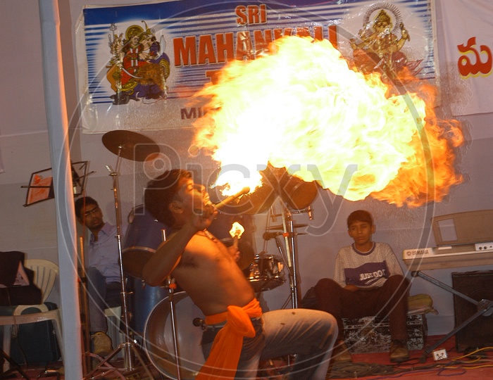 An Artist Performing Fire Stunts on Stage