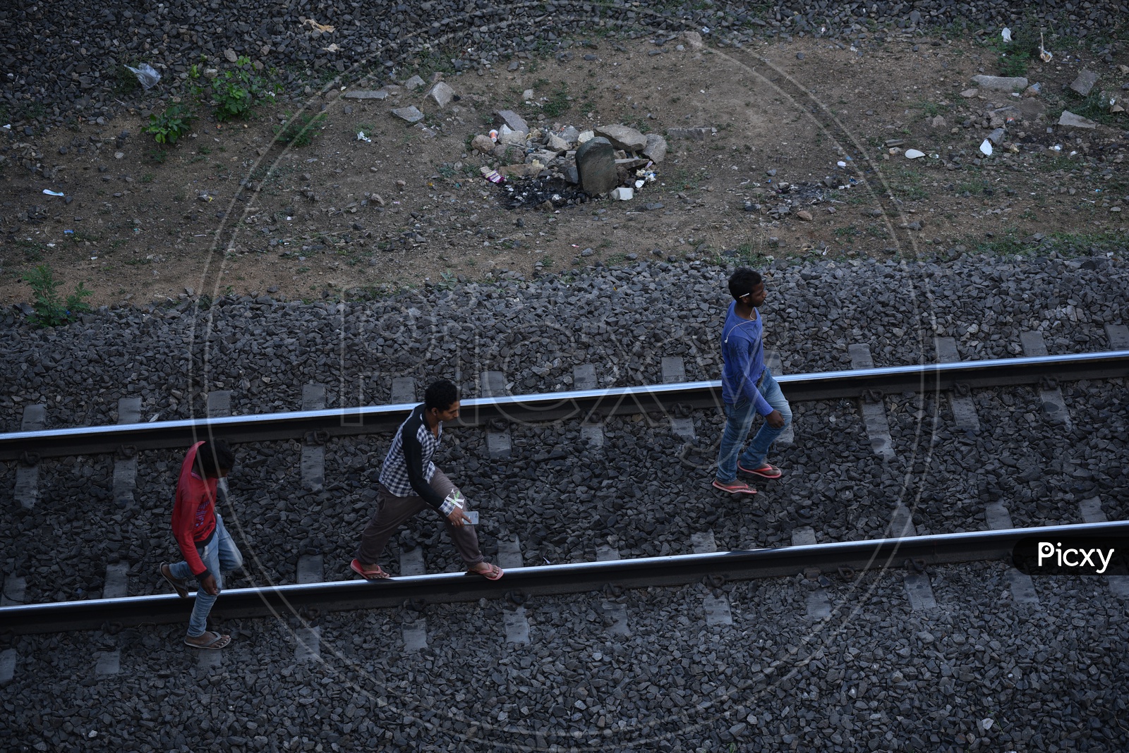 Young men walking on a railway track