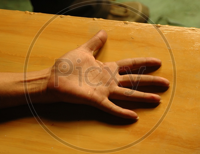 Palm of a hand on the wooden board