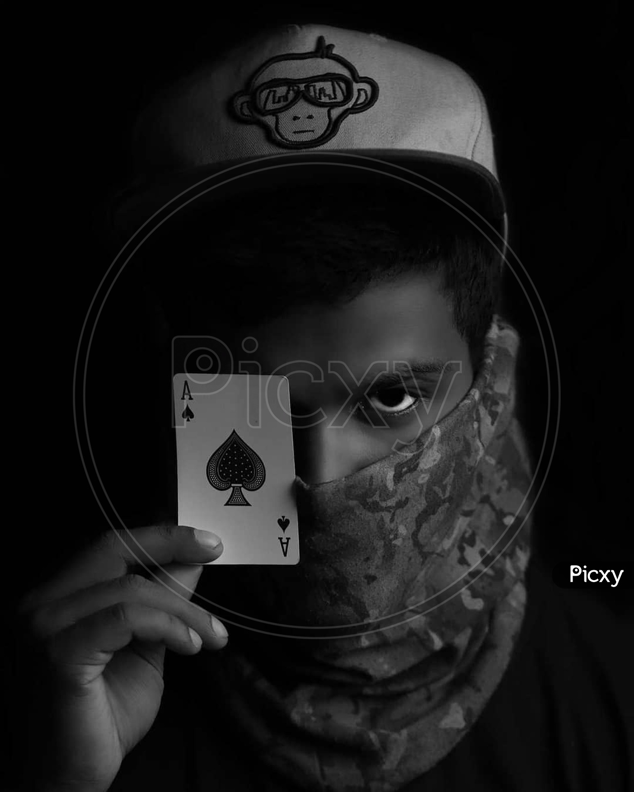 portrait of a person with mask,cap and with solitaire card in the hand