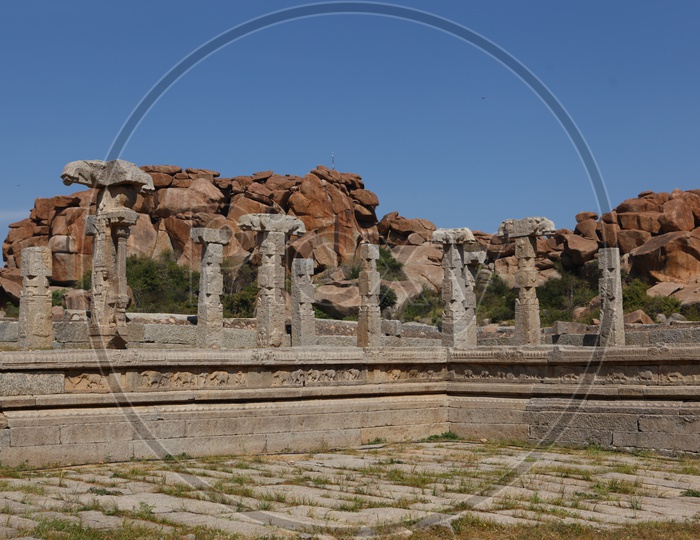 Granite rocks supported by the columnar pillars alongside the temple ruins