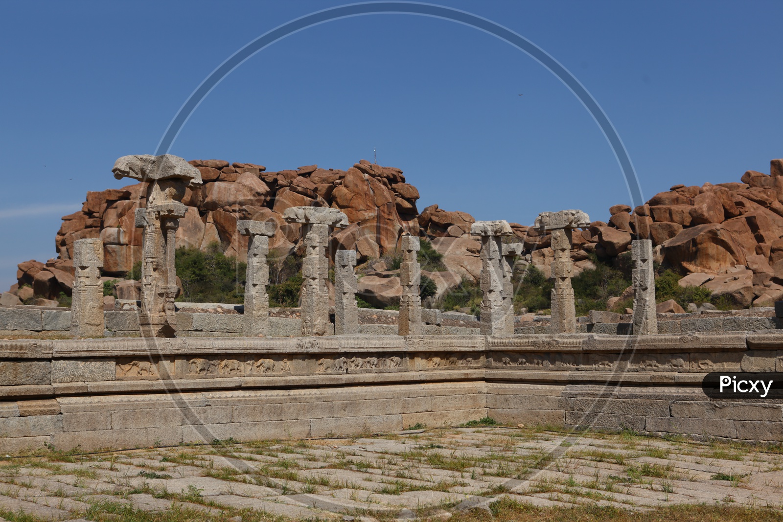 Granite rocks supported by the columnar pillars alongside the temple ruins