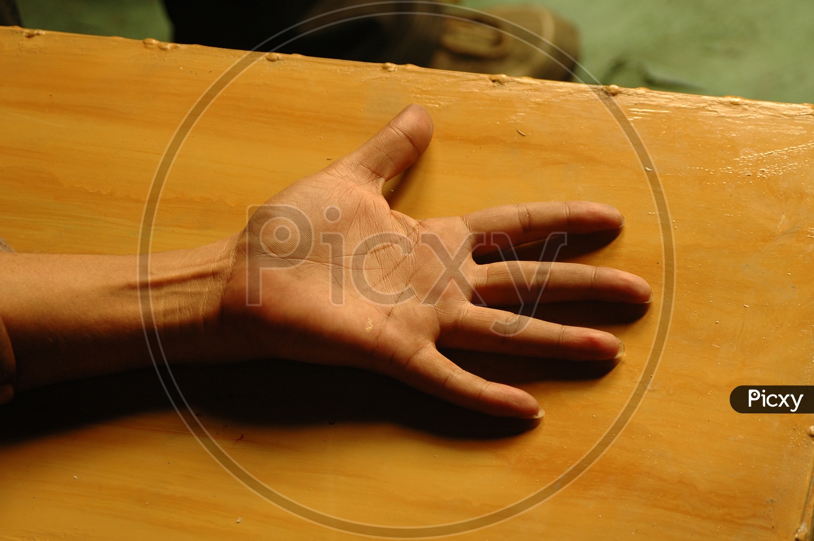 Palm of a hand on the wooden board