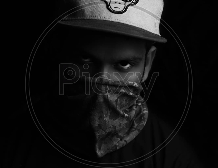 portrait of a person with mask and cap in the dark