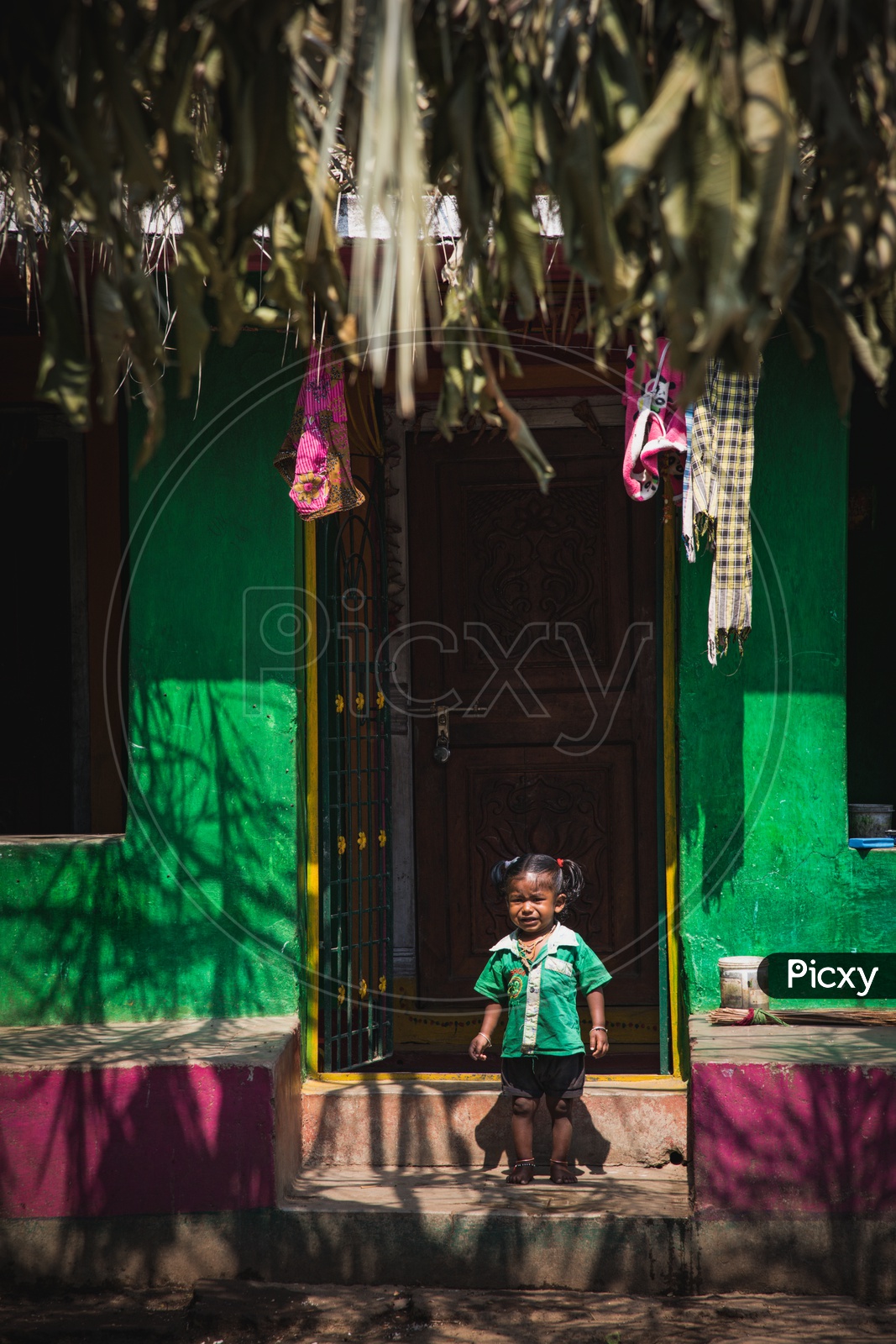 A Young Child Crying At Her House Door Step In Tribal Village