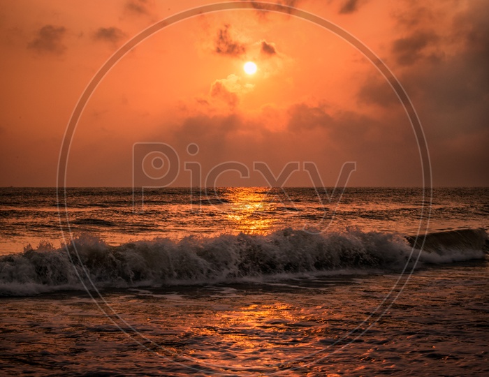 A Beautiful Sunset Over a Sea With Sea Waves Beating The Shore